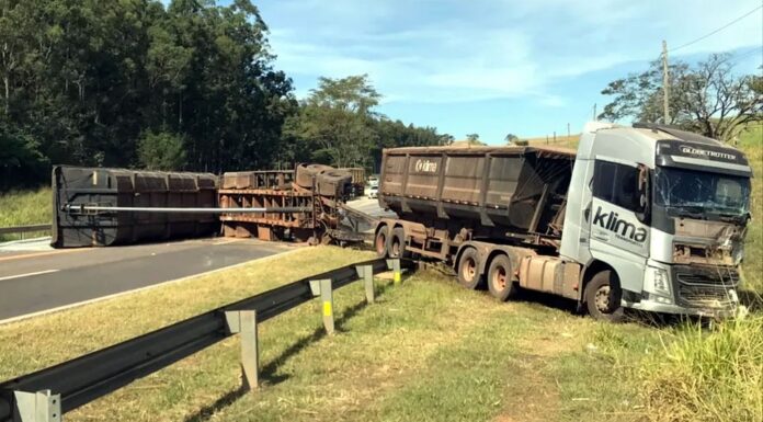 Caminhão bate contra carreta, capota e derrama carga de milho sobre a rodovia SP-294, em Flórida Paulista