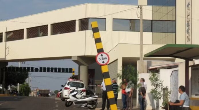 Caminhão colide com placa de sinalização de altura, que cai e atinge carro estacionado, em Dracena